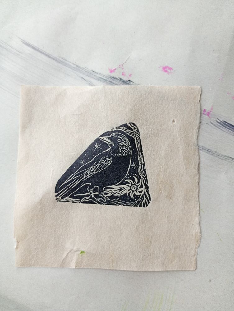 A small wood engraving print of a jackdaw & meteor printed in midnight black on handmade paper