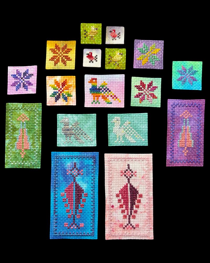 Tatreez patches on various, colorful aida cloth and stitched with gradient thread. There are medium and large patches of cypress trees with checkered borders, moons of Bethlehem, pigeons, and teeny tiny birds.