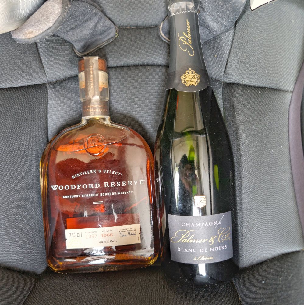 A bottle of bourbon and a bottle of champagne.
