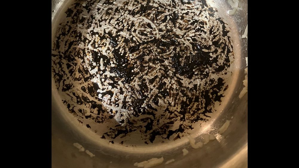 Verkohlte Reisreste am Topfboden.