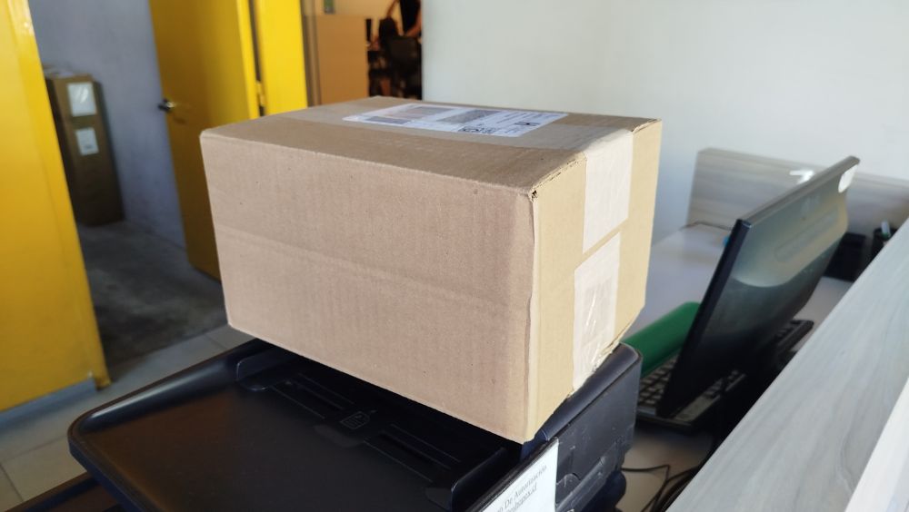 A brown cardboard box sitting over a desk