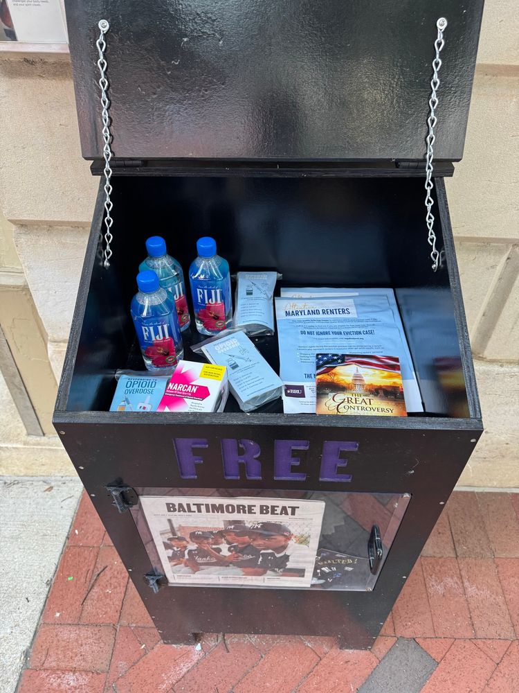Photo of a Baltimore Beat box with donated water, Narcan, and other things inside. 