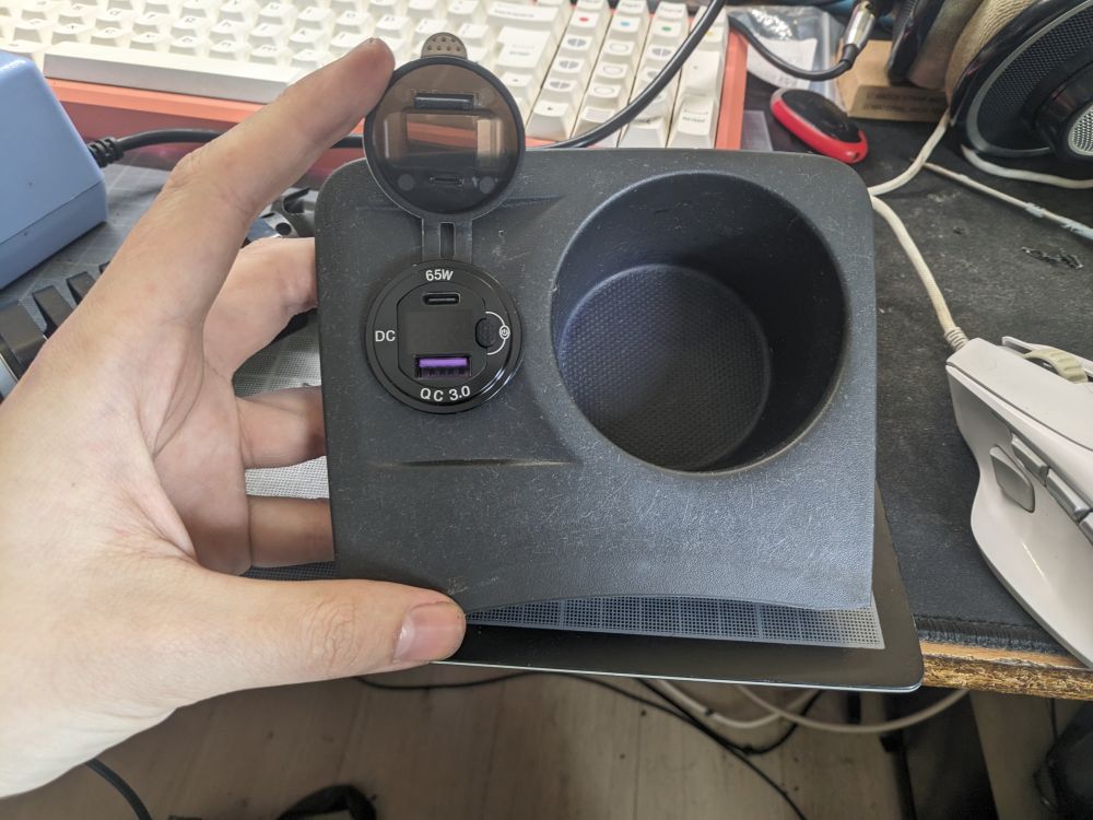 Photo of the same piece of plastic, a USB charger now installed into the hole