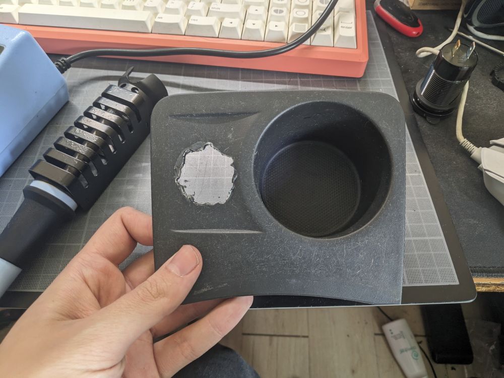 Photo of a piece of plastic trim with a 2 centimeters hole roughly made in it