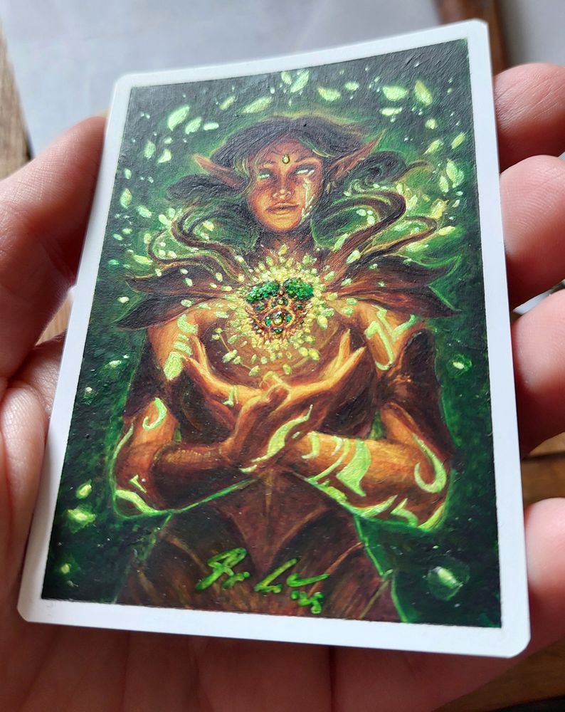 Another view of the same card, tilted to show off the shinies. A keen-eyed viewer might notice the gem on her forehead and the three big ones in the amulet are raised and extra shiny.