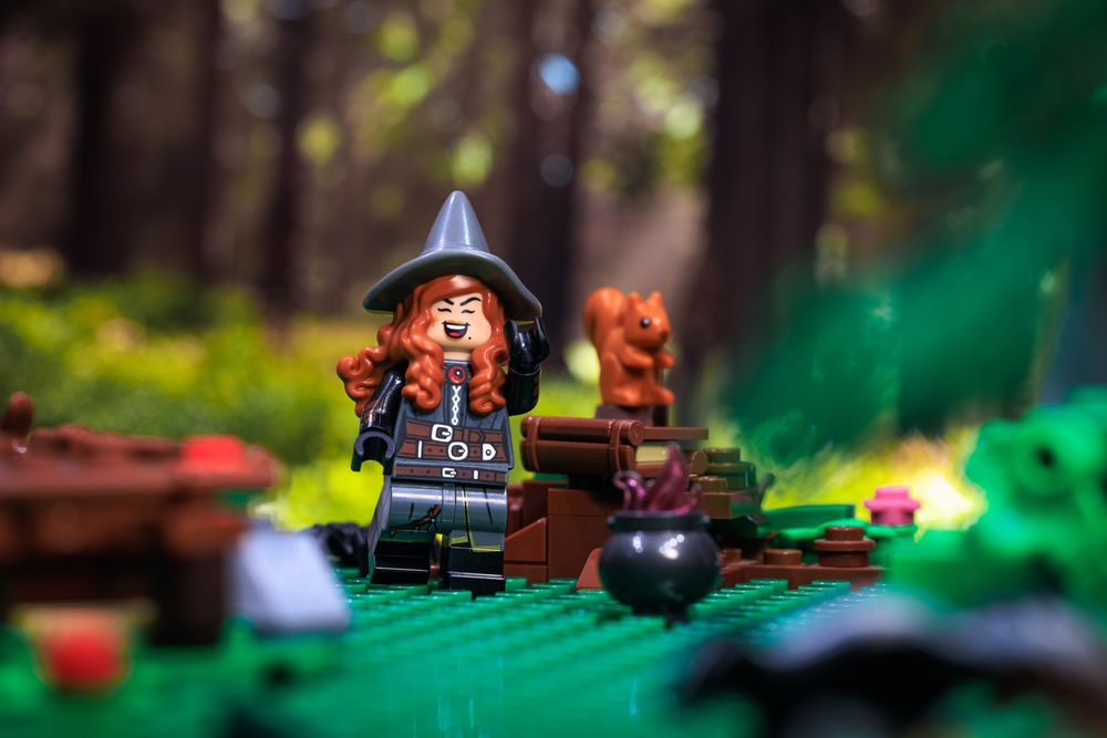 Wicked witch LEGO minifig of the PNW, laughing with a squirrel in the woods