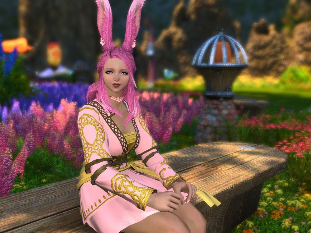 Demi the Viera sitting on a bench with some flowers in the background.