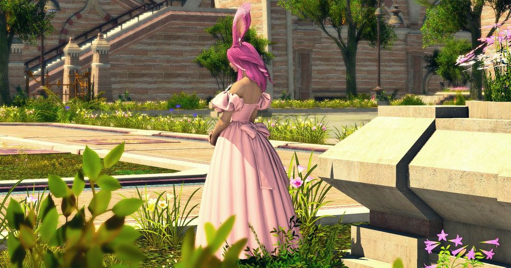 Demi standing in a garden with a pink dress on, turned away from the camera.