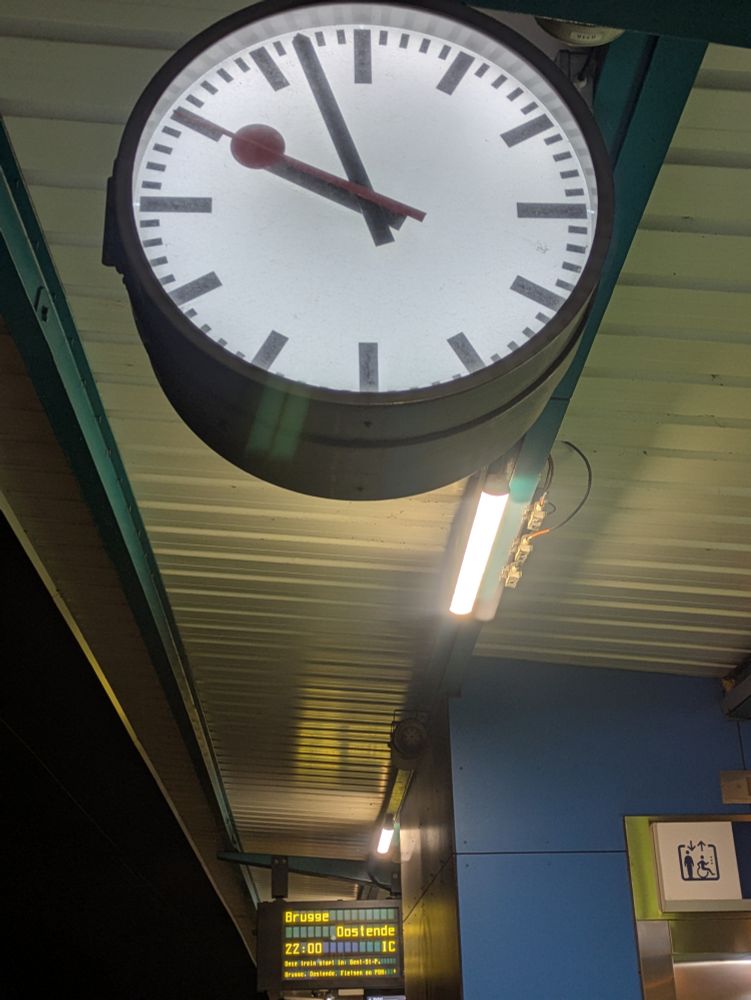 A large station clock at Ghent St Pieter's Station showing just before 10.00