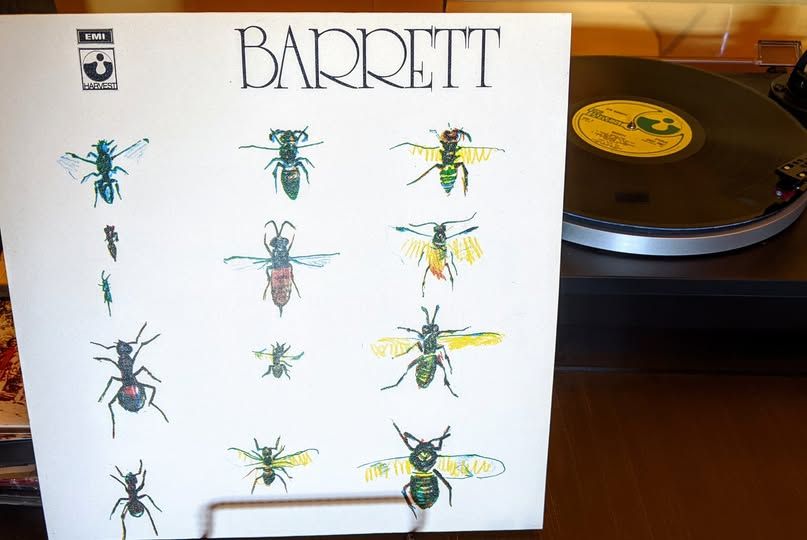 However, as with his first solo album “The Madcap Laughs,” David Gilmour was producer and bassist. Rick Wright played keys and Jerry Shirley (Humble Pie) drums. Recording was infamously difficult, drawn out over 15 sessions, due to Syd's erratic mental state. Critical reaction was mixed, though this album is treasured by fans. Tracks include ‘Gigolo Aunt’ ‘Dominoes’ ‘Effervescing Elephant’ + ‘Baby Lemonade.’ Cover drawings by Syd. 

Barrett was joined by Humble Pie drummer Jerry Shirley and Pink Floyd members Rick Wright (organ) and Dave Gilmour (guitar). Gilmour and Wright acted as producers as well. Instrumentally, the result is a bit fuller and smoother than the first album, although it's since been revealed that Gilmour and Wright embellished these songs as best they could without much involvement from Barrett, who was often unable or unwilling to perfect his performance. The songs, however, are just as fractured as on his debut, if not more so. "Baby Lemonade," "Gigolo Aunt," and the nursery rhyming "Effervescing Elephant" rank among his peppiest and best-loved tunes. Elsewhere, the tone is darker and more meandering. It was regarded as something of a charming but unfocused throwaway at the time of its release, but Barrett's singularly whimsical and unsettling vision holds up well.