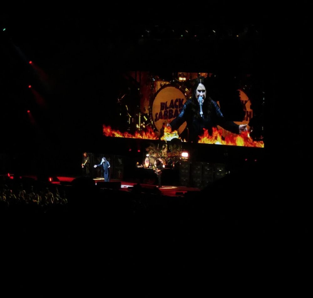 Picture is of Black Sabbath during the 2016 tour The End. Ozzy Osbourne is on the big screen singing, while flames dance beneath him.