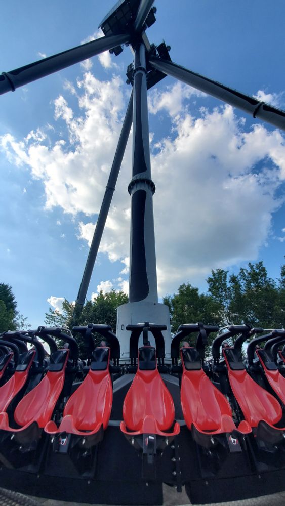 Closeup view of the red seats and raides shoulder restraints of the Black Widow pendulum ride at Kennywood.