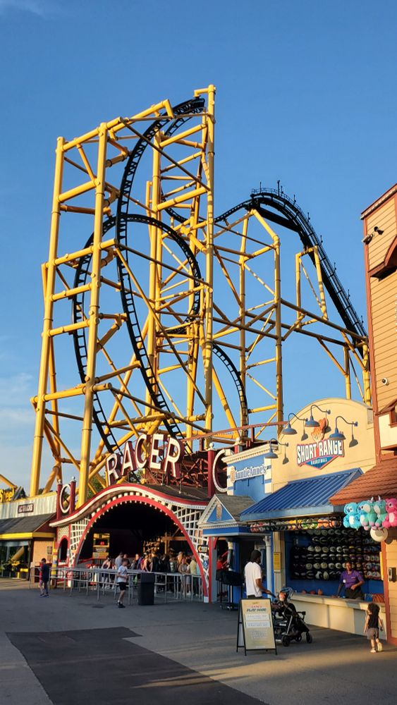 Two Kennywood roller coasters, the entrance sign to Racer roller coaster with Steel Curtain towering high above it.