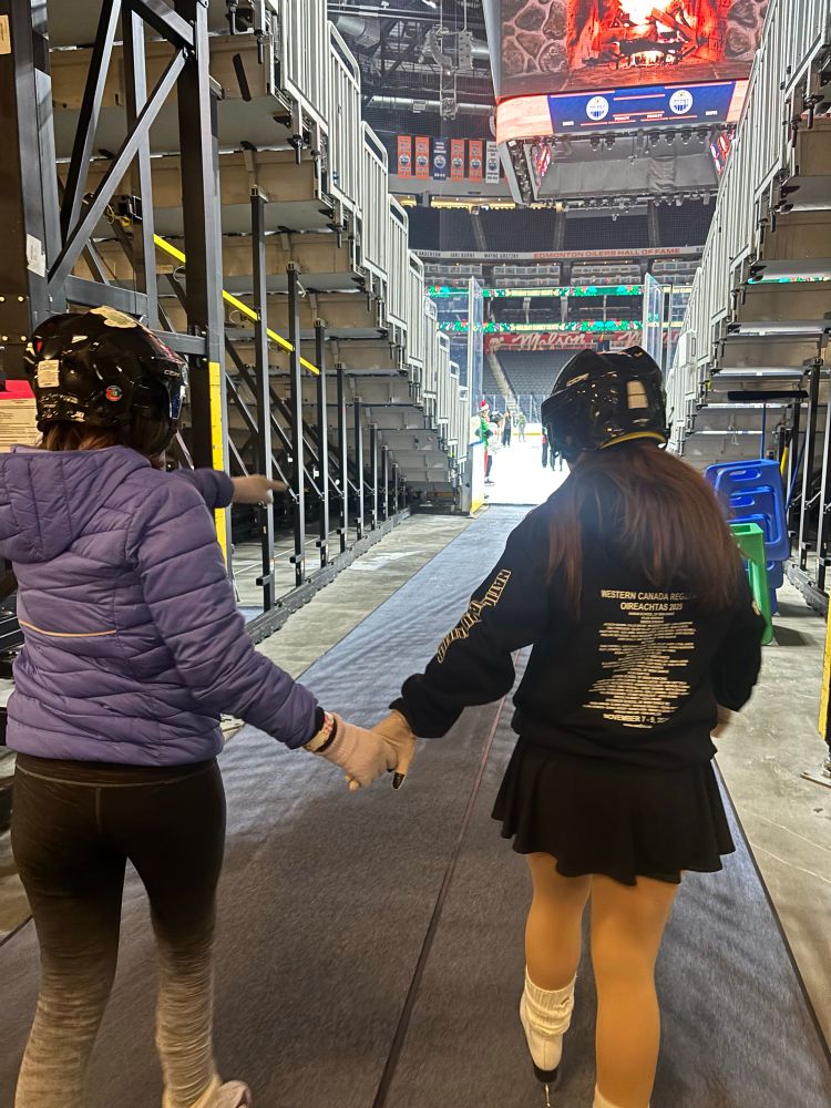 Aoife and Róisín holding hands walking down the tunnel to the Rogers place ice 