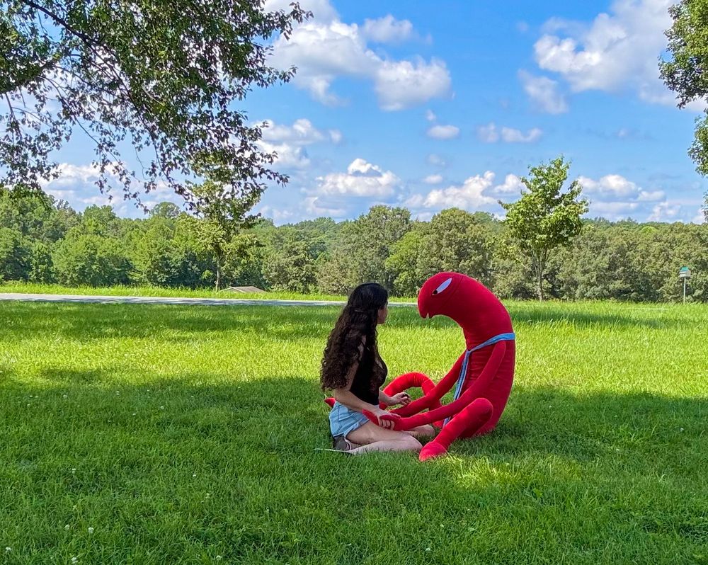me sitting in the grass with allan from smiling friends