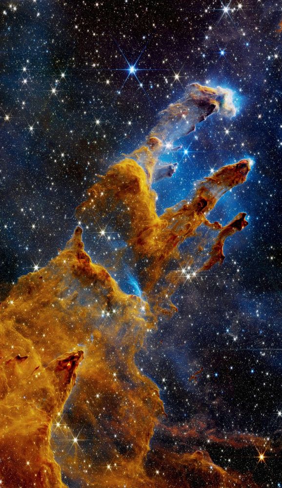The image showcases the iconic Pillars of Creation in the Eagle Nebula, captured in stunning detail by the James Webb Space Telescope. The towering pillars of gas and dust, sculpted by the intense radiation and winds from nearby stars, appear in a rich tapestry of colors. The image reveals intricate details within the pillars, including newborn stars forming within dense pockets of gas, and jets of material being ejected from these young stars. This image offers a glimpse into the dynamic and awe-inspiring process of star formation, where new stars are born and shape their surroundings.