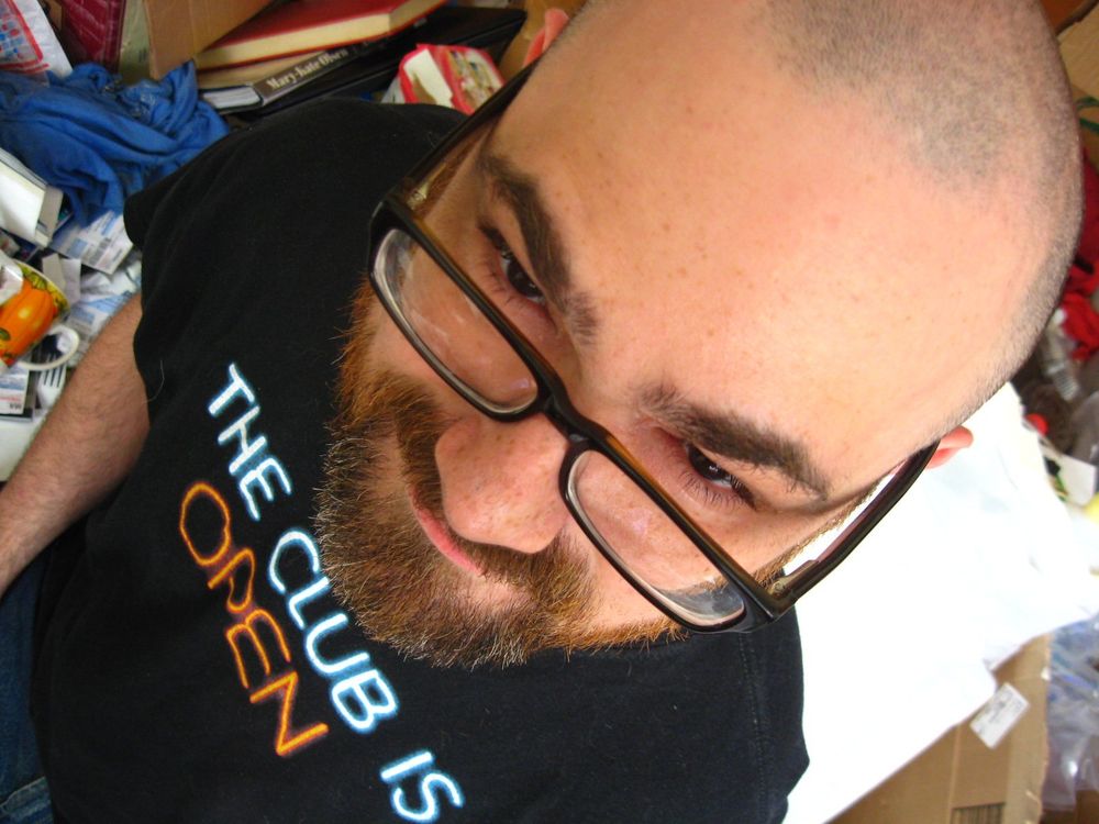 Messy old room photo with me wearing a Guided By Voices shirt that reads, naturally, "The Club is Open"