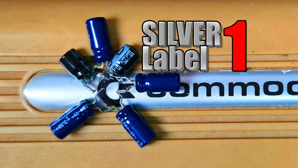 Youtube thumbnail. 
A C64 Silver label, label, with a bunch of leaking capacitors arranged around the commodore logo. Title: SILVER Label 1
