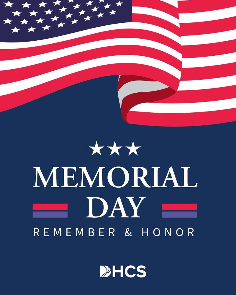 Memorial Day promotional poster featuring an American flag in the background with the text 'Memorial Day Remember & Honor' overlaid. The logo for HCS is visible at the bottom.
