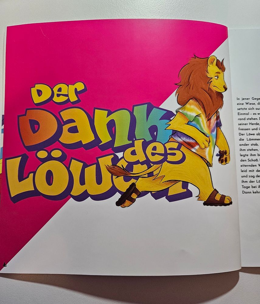 A page of a square book.
The background is diagonally divided into magenta and white.
In the center, large outlined letters read "Der Dank des Löwen".
There is an illustration of an anthropomorphic lion next to it. The lion is wearing a rainbow tie-dye t-shirt and sandals.