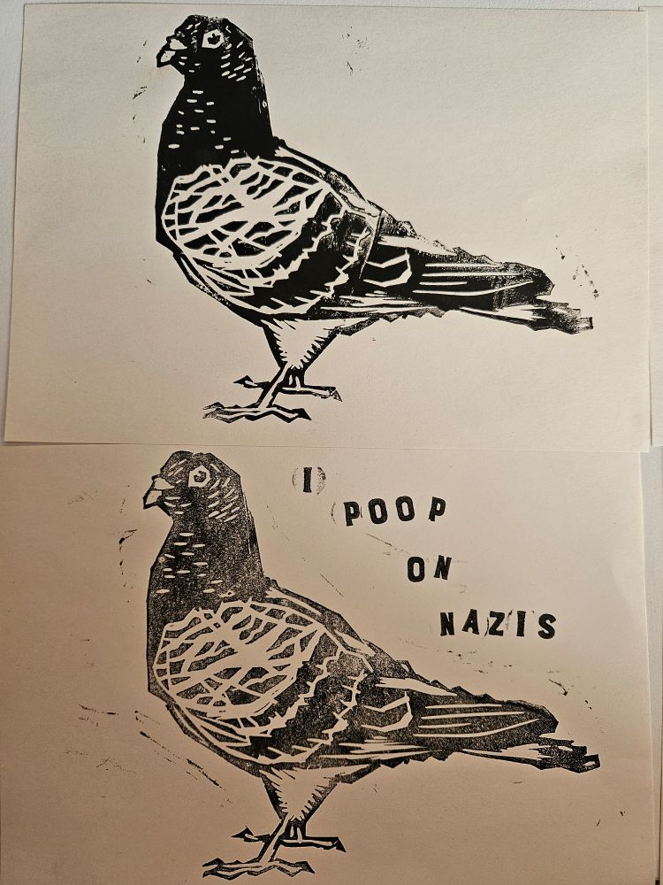 Two prints. Both depict a standing pigeon facing the left. The print on the bottom features text on the right next to the pigeon that reads "I poop on Nazis". Each word is in it's own row and the letters aren't uniform, due to them having been stamped on individually.