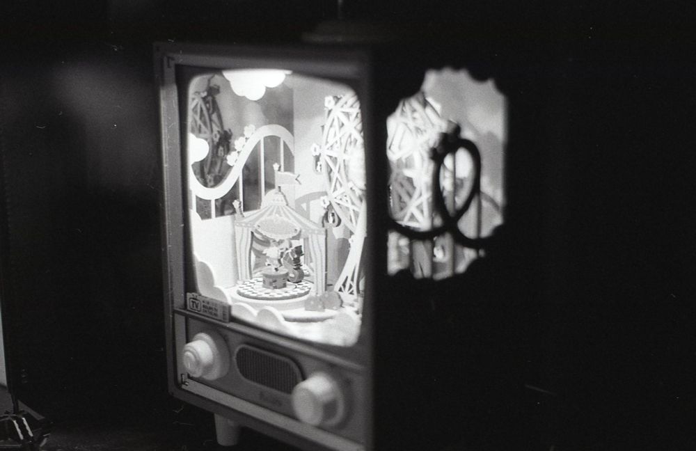 a close-up of a small wooden carnival set in a small retro tv (I think??)
