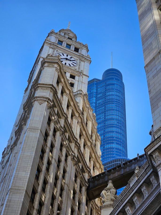 Photo from street level on Michigan Avenue looking up at the Wrigley Building clock tower while Trump Tower Chicago looms in the background