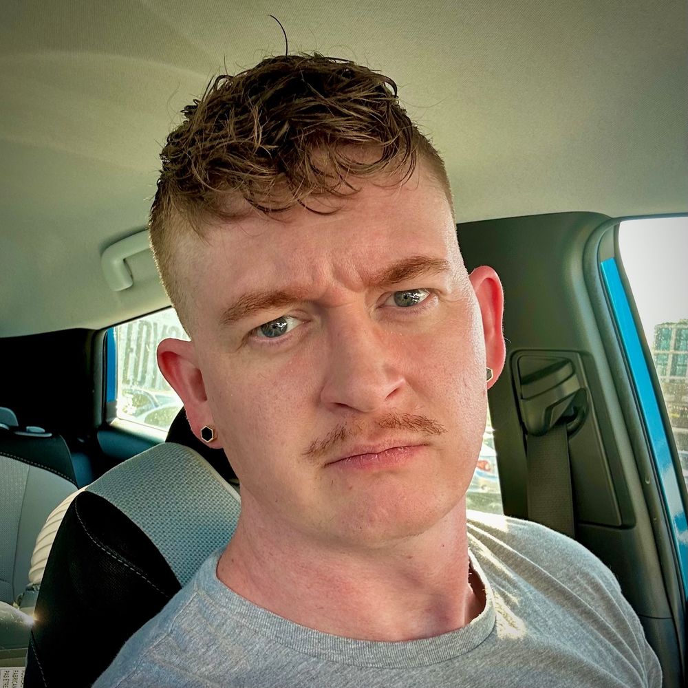 Casey frowning at the camera with a short haircut. 