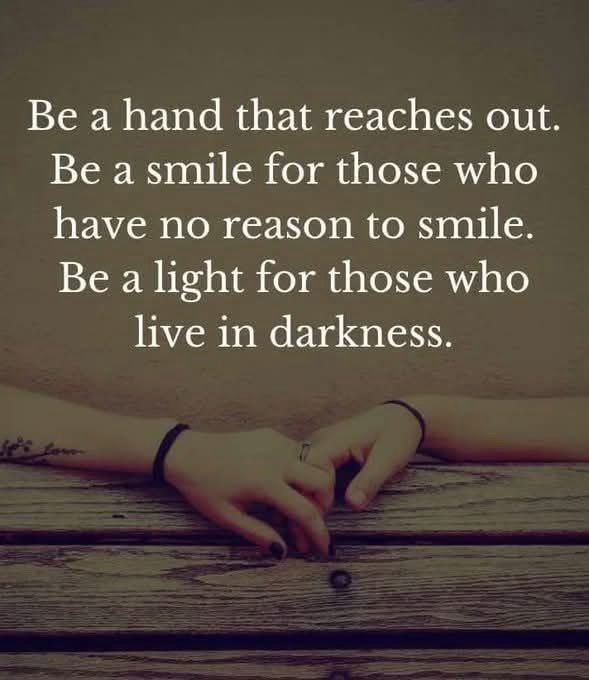 a sepia toned photo is a close in shot of two forearms and hands intertwining fingers across the top of a bench - one forearm has a tattoo and fingers painted - the other is without - there are wristbands or hair ties on both - text in the upper part of the image reads:

Be a hand that reaches out.
Be a smile for those who have no reason to smile.
Be a light for those who live in darkness.