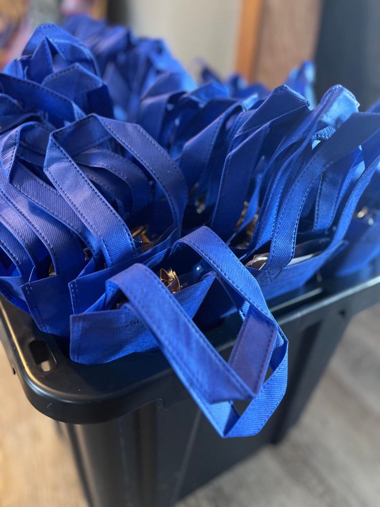 Round One: stuff the little doll-sized tote bags with gifts from Resin Rose. This year the bag is a bright royal blue. This bazillion gallon tub goes three layers deep with treats.