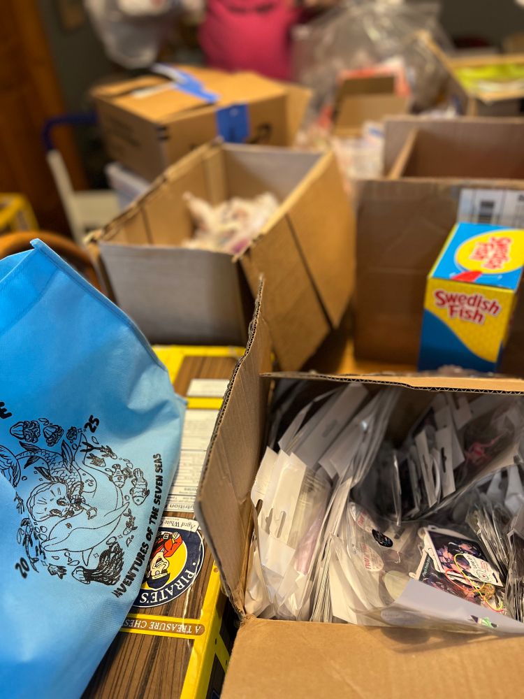 Round Three: special gifts. The table is piled high with boxes and bags of goodies donated to the show. 