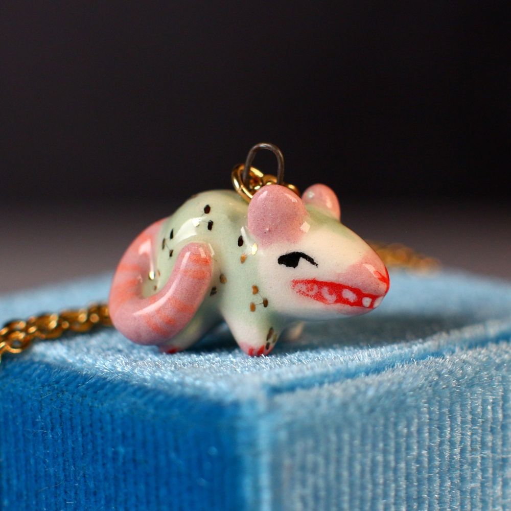 Handmade ceramic opossum pendant hisses at you. 