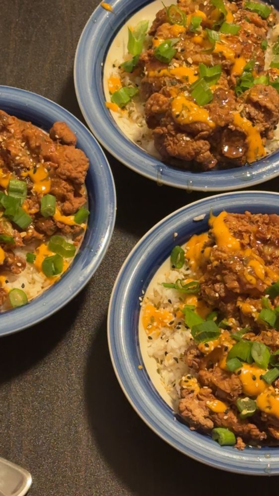 Three bowls of Mochiko chicken over coconut rice, gochujang aioli and miso sauce drizzle with scallions and furikake on top