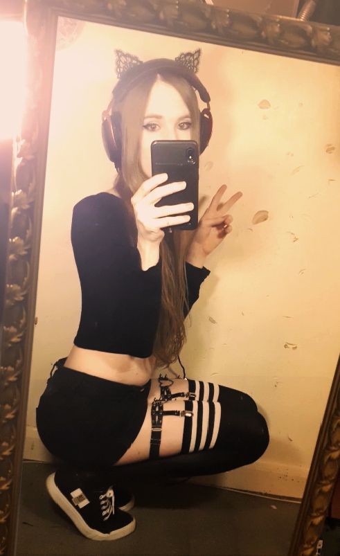 Mirror selfie, cat ears on, sneakers, thigh highs and garters, crop top, headset, overall looking like a bad bitch