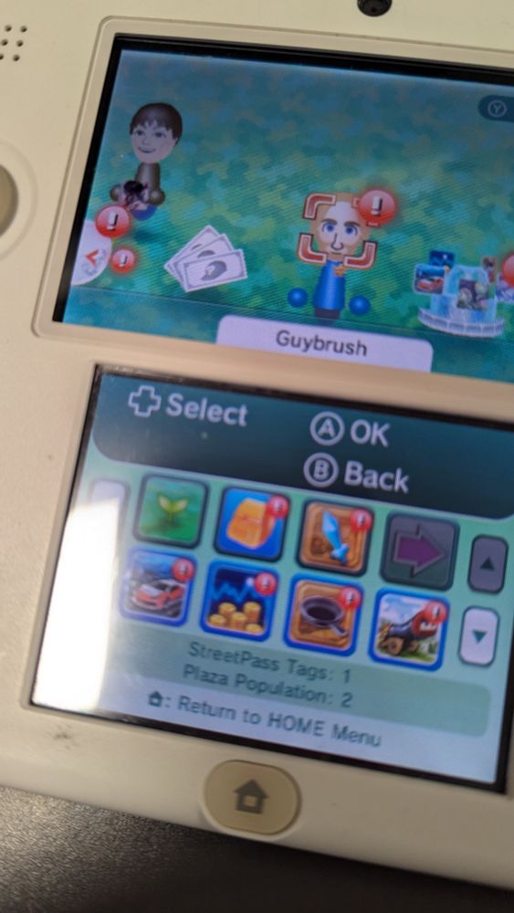 A Nintendo 2DS with streetpass. It has the main character, Guybrush, and one other Mii holding Street fighter 4.