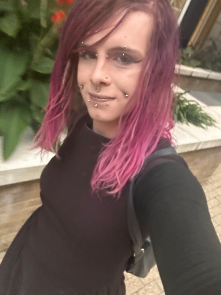 Me wearing a skirt with pink hair and earrings