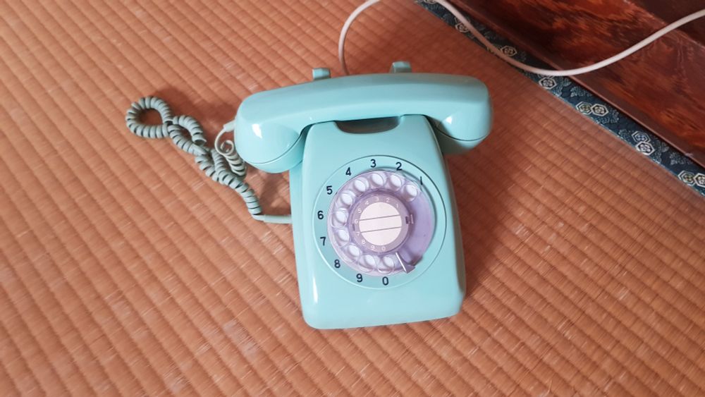 Ein türkisfarbendes Wählscheibentelefon