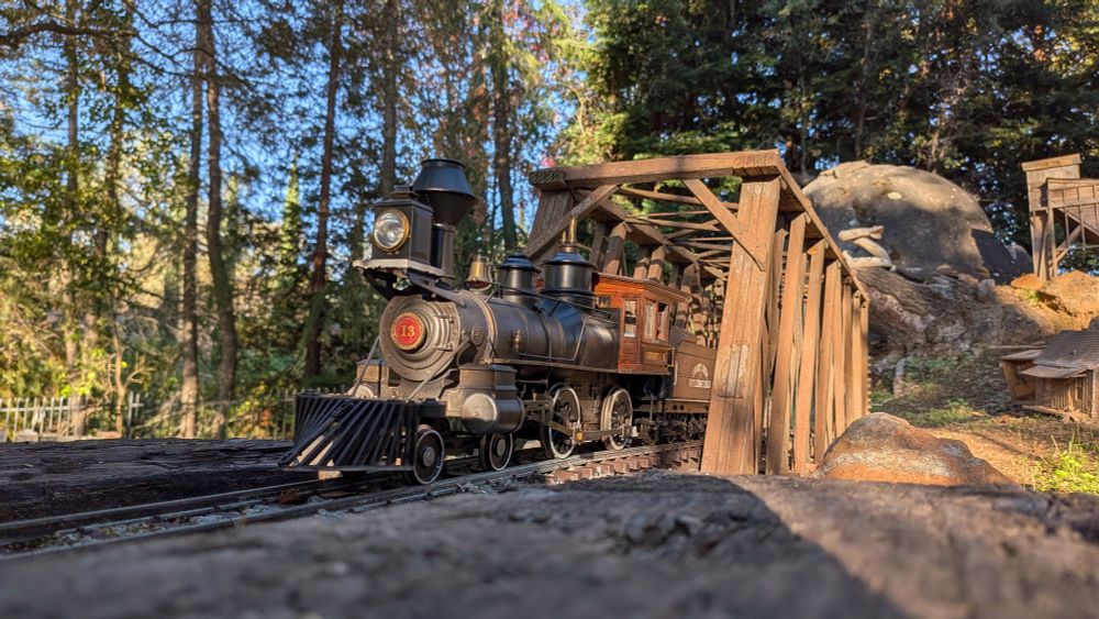 A Bachmann 4-4-0 I custom painted rolls over a trestle 