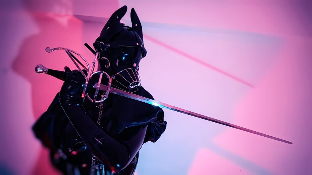 puppydoll holding its rapier as if preparing for a fight, head turned to face the tip of its blade
