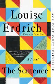 Cover of the The Sentence, a novel by Louise Erdrich.  Over shows red, yellow, white, black, blue and teal triangles connected una diamond like a quilt. Some of the triangles are beaded.