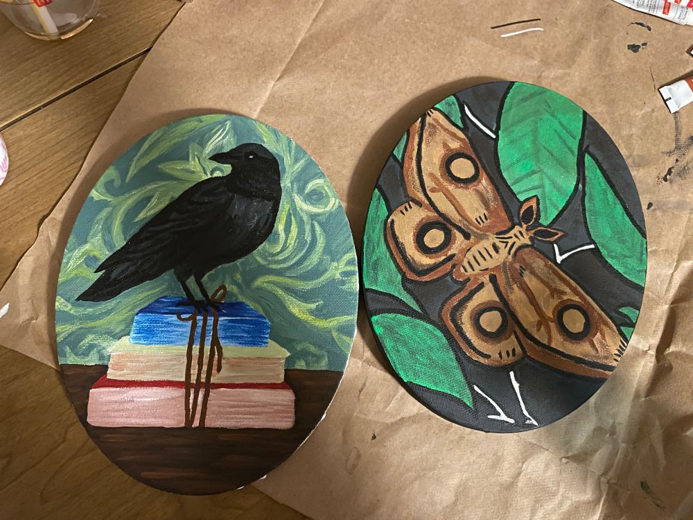 Two paintings - one of a crow on a stack of books and one of a brown moth.