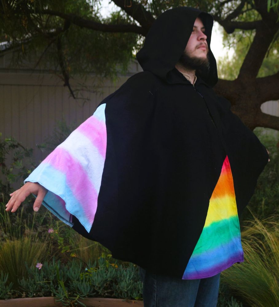 Cape with black base and pride flag front, back and sides. Sides are trans pride flags and front and back are LGBT pride flags. Flags are made via tie dye.