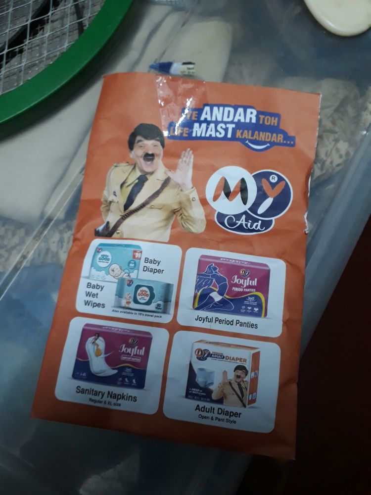Back of pharmacy paper bag with an ad for diapers featuring a model with short moustache and uniform that sort of resembles Adolf Hitler