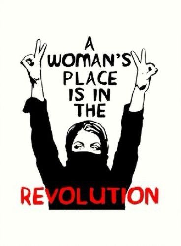 A masked woman raises her arms above her head. The writing says a woman's place is in the revolution.