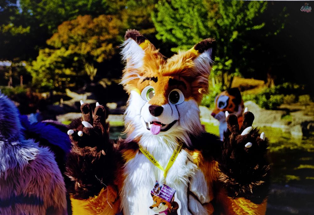 A Fox Fursuiter showing two "peace" signs.