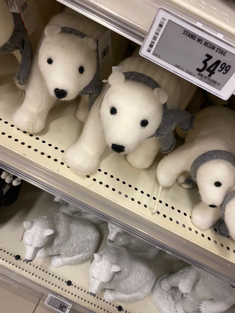Rows of polar bear christmas decorations on a store shelf.