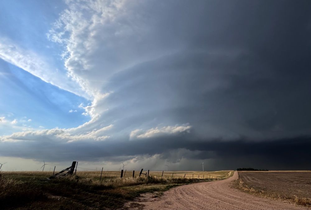 A HUGE cloud spirals up over barren fields