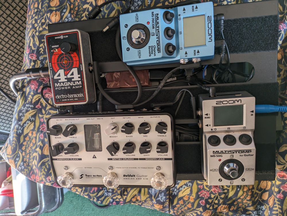 A small pedalboard with two Zoom Multistomps, a TwoNotes Revolt and an EHX MAgnum 44 on it