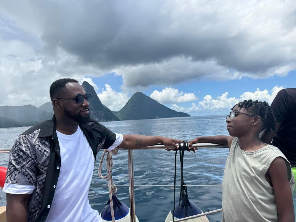 KC and Starboy on a boat with St. Lucia's Pitons in the background.
