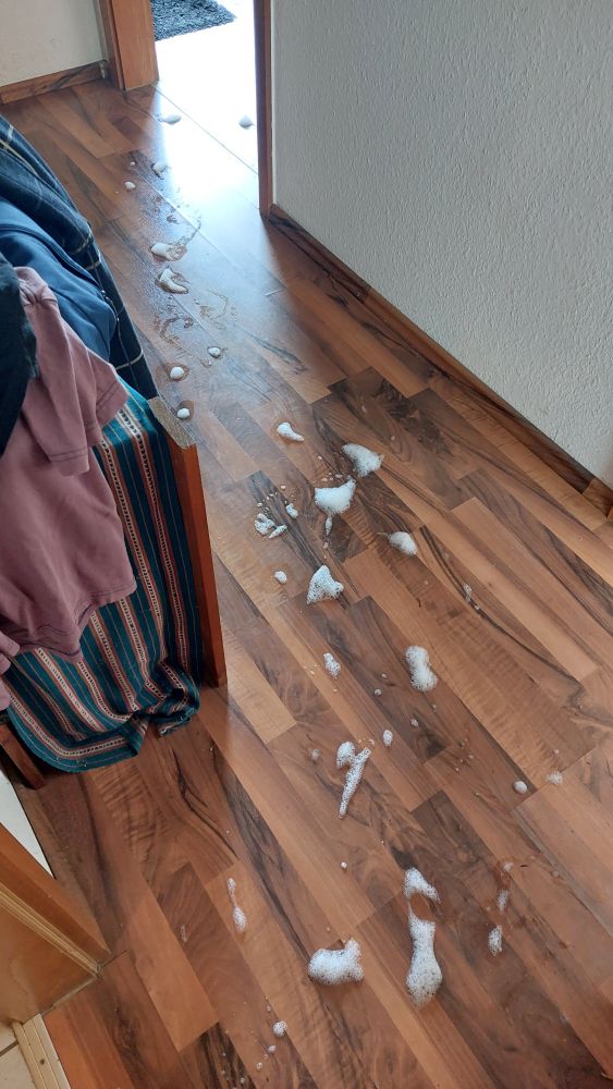 Ein Spur von Schaumflecken führt über den Boden eines Raumes